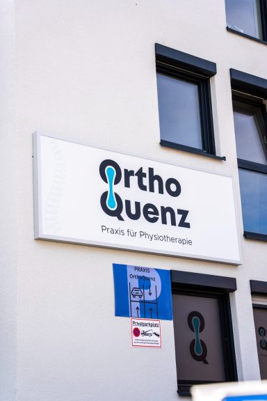 Schild mit der Aufschrift "OrthoQuenz", Praxis für Physiotherapie.